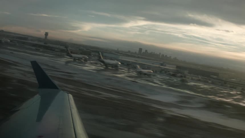Wing side view of a plane taking off in the rain