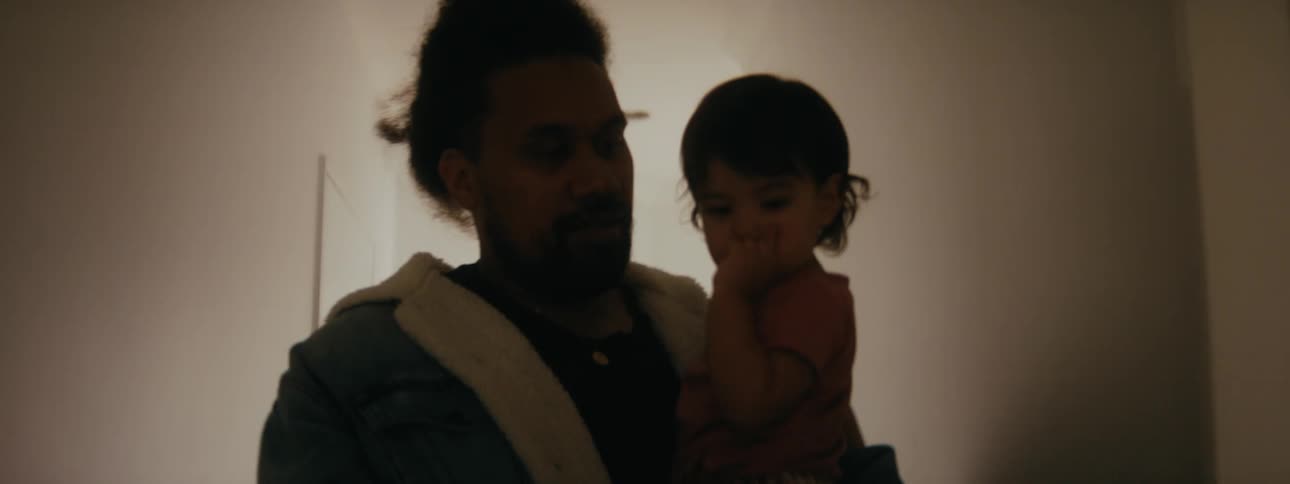 Father carries child down hallway