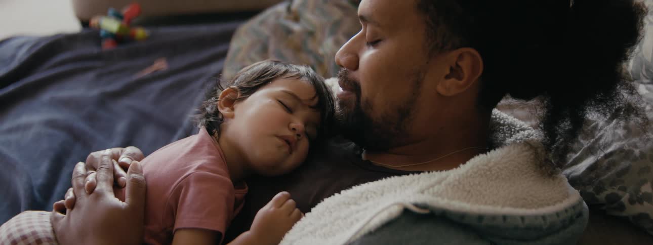 A father is taking a nap with his daughter