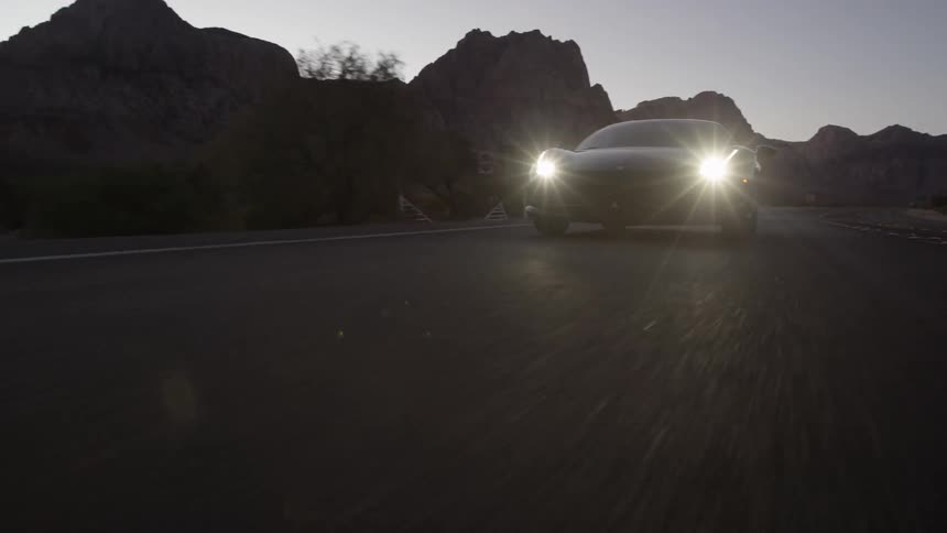 A sports car turns onto a desert road