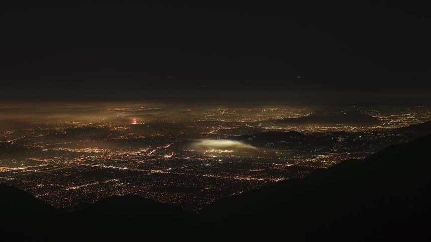 The lights in a big city shine and twinkle as traffic moves across town and buildings are lit up