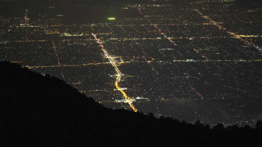 Cars are driving through a downtown city at night