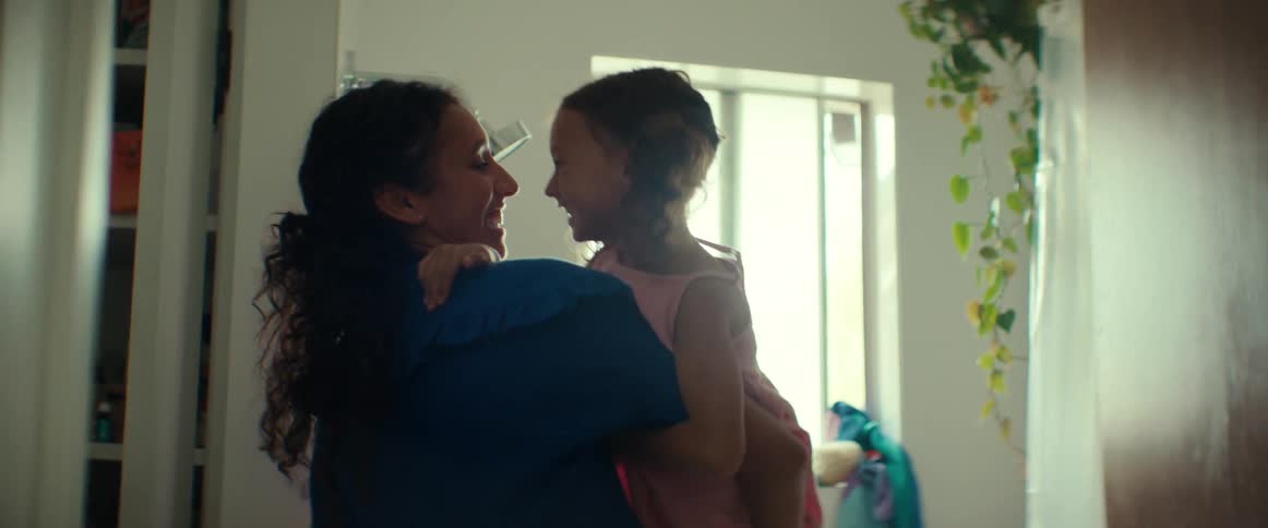 A mother and daughter are playing and laughing in a bathroom of a house
