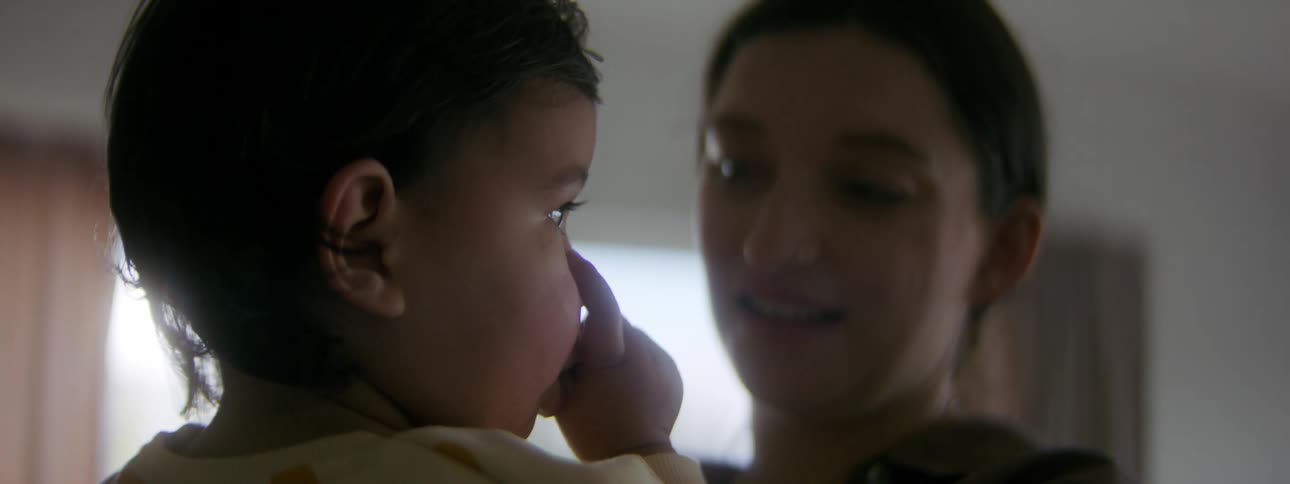 A young mother is holding her young toddler
