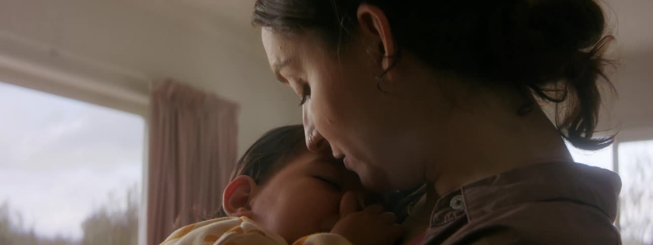 A mother kissing her baby on the forehead