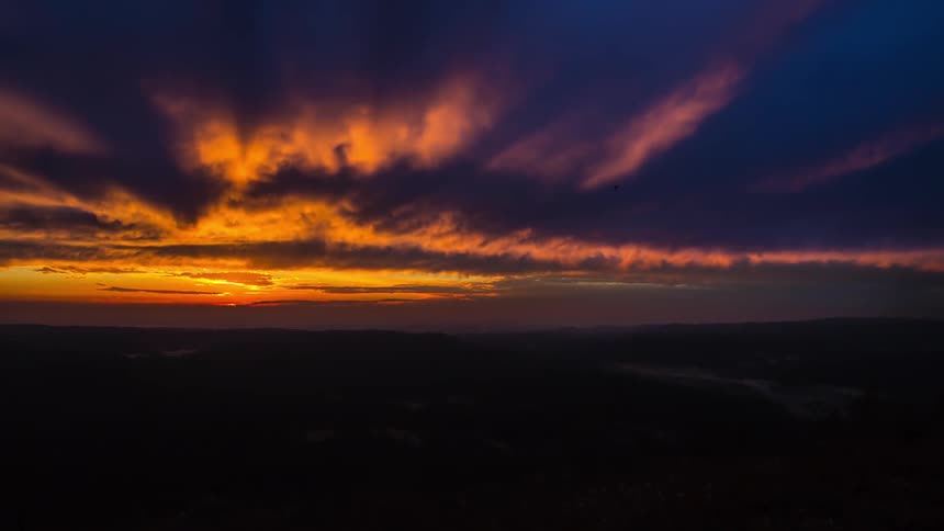 The sun sets on a cloudy day