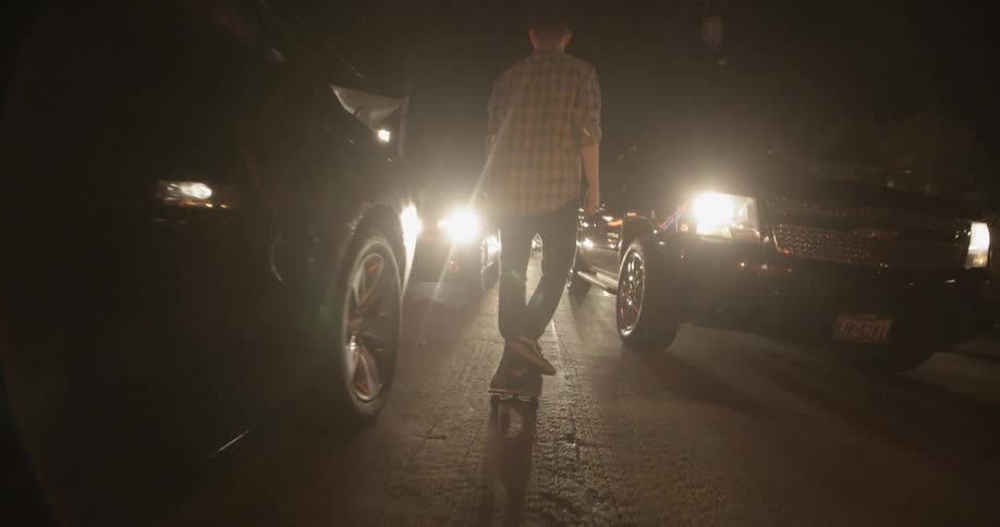 A man skateboards through traffic