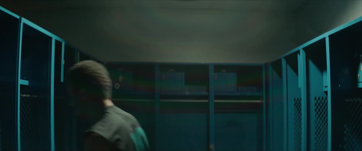 A man jumps around a locker room