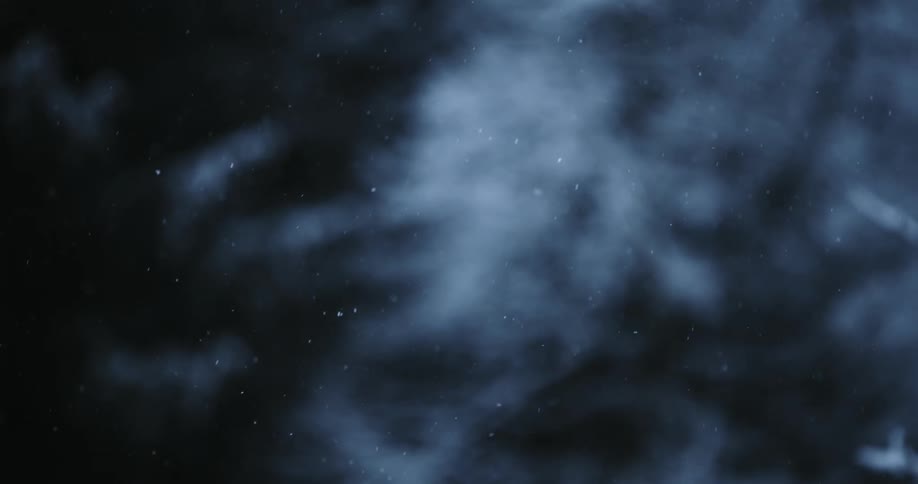 Snow falling against a cloudy night sky