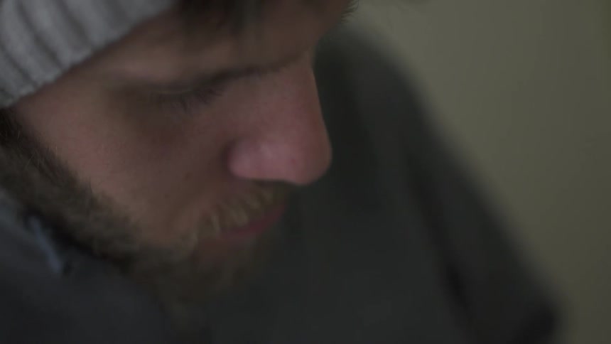 A man is wearing headphones and looking down