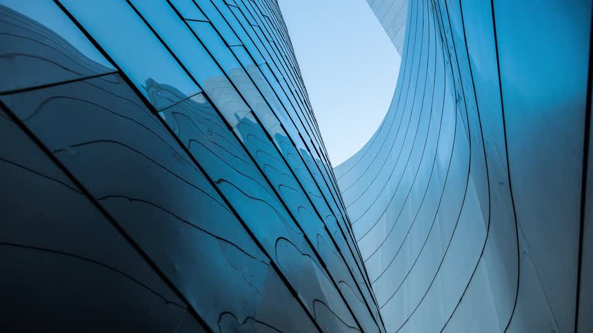 The curves of the glass windows on a large skyscraper go up to the top and twist and turn