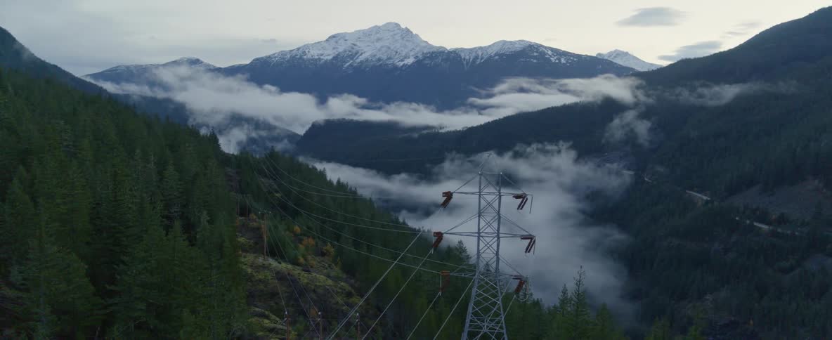 Aerial over a cell tower in a forested mountain range