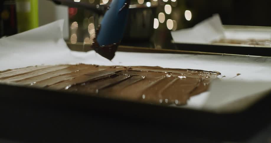 Chocolate icing is put on a pan