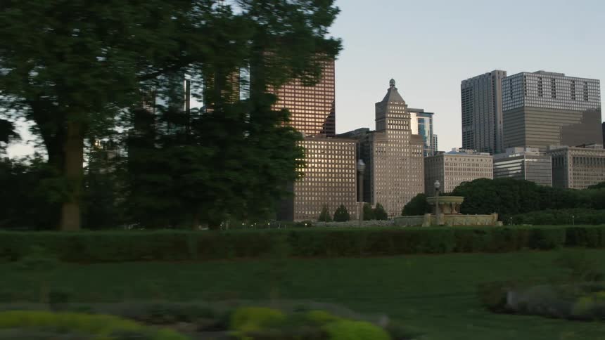 Tall skyscrapers on the city skyline in front of a park at morning