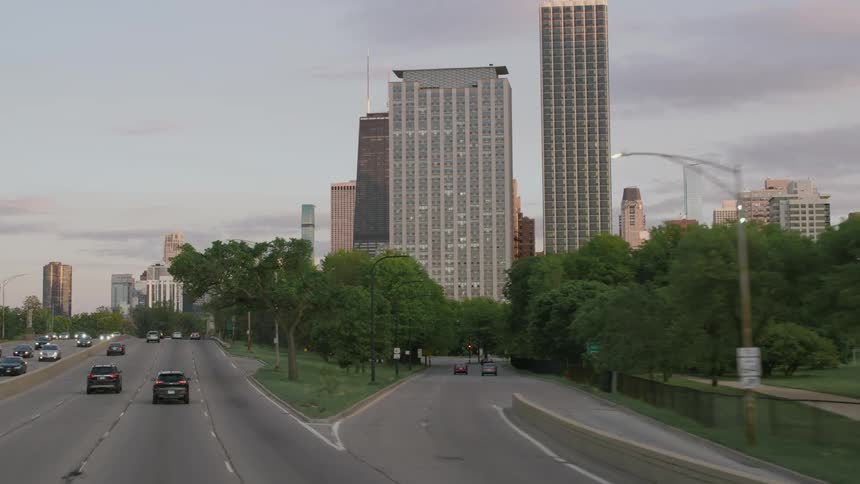 Vehicles drive under a bridge as they head toward downtown