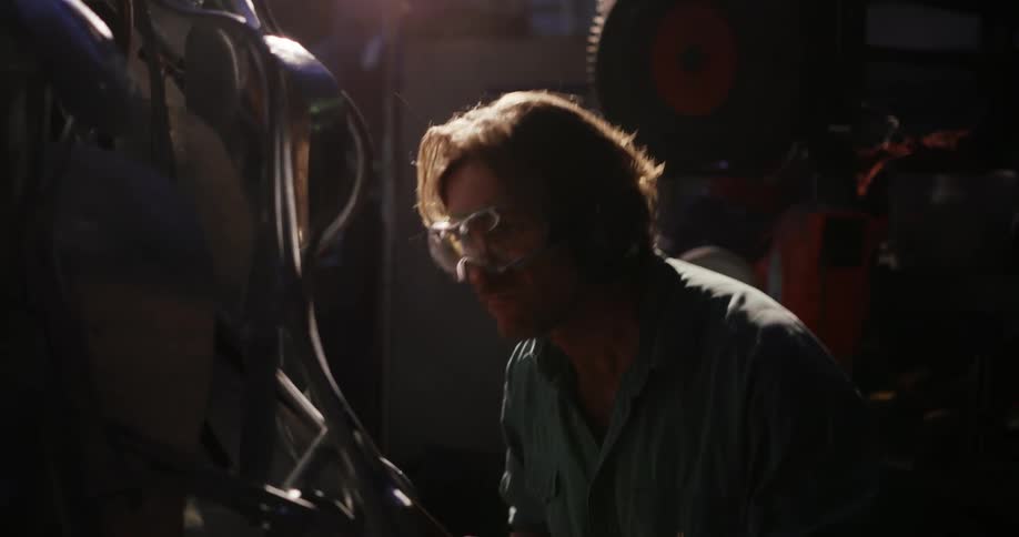 A man uses a torch in a workshop