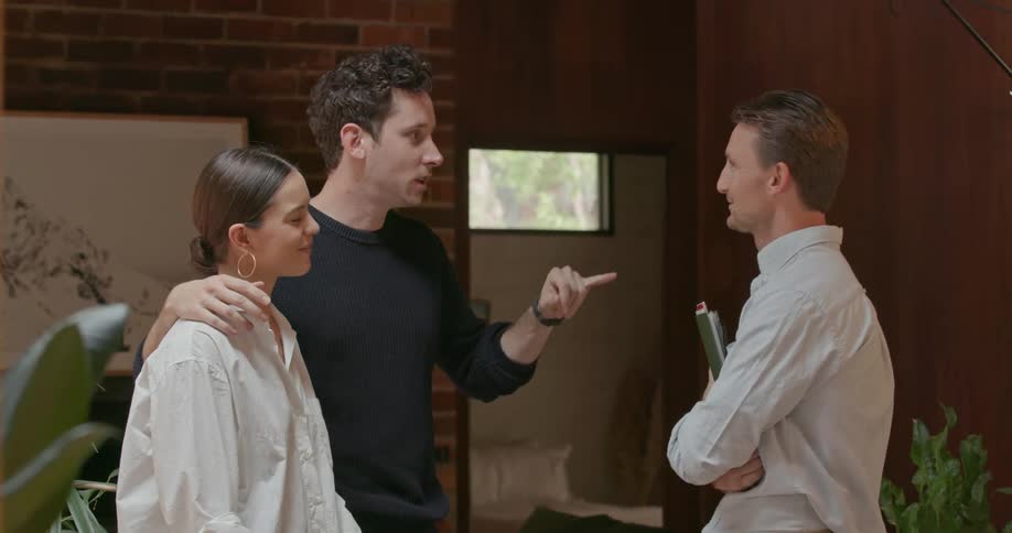 A man and woman are talking to a man with a clipboard