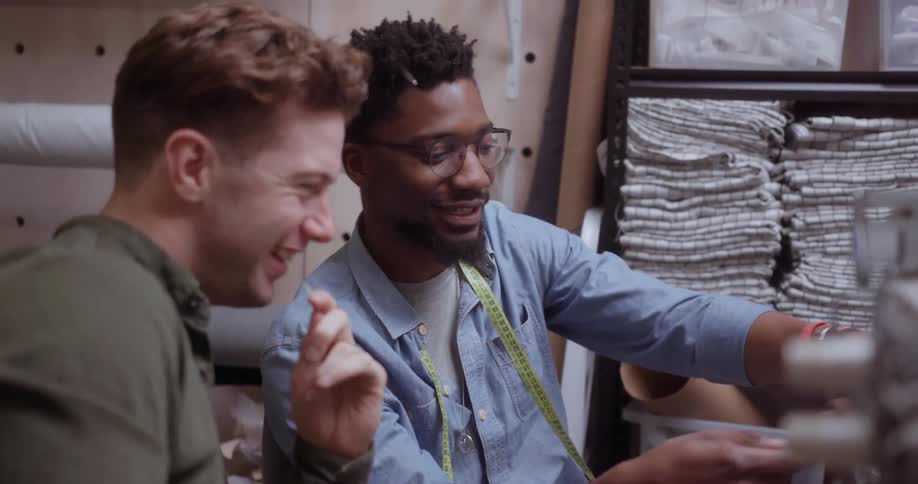 Two fashion designers smile while talking