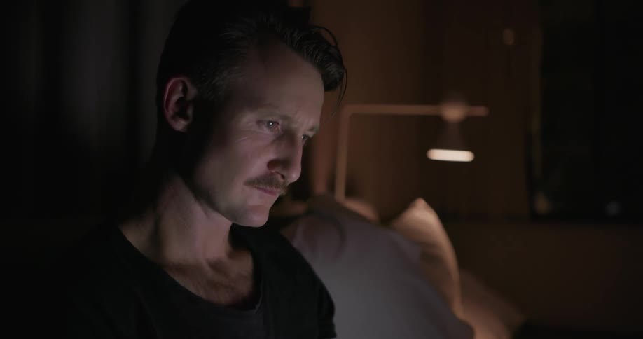 A man is using his laptop in bed