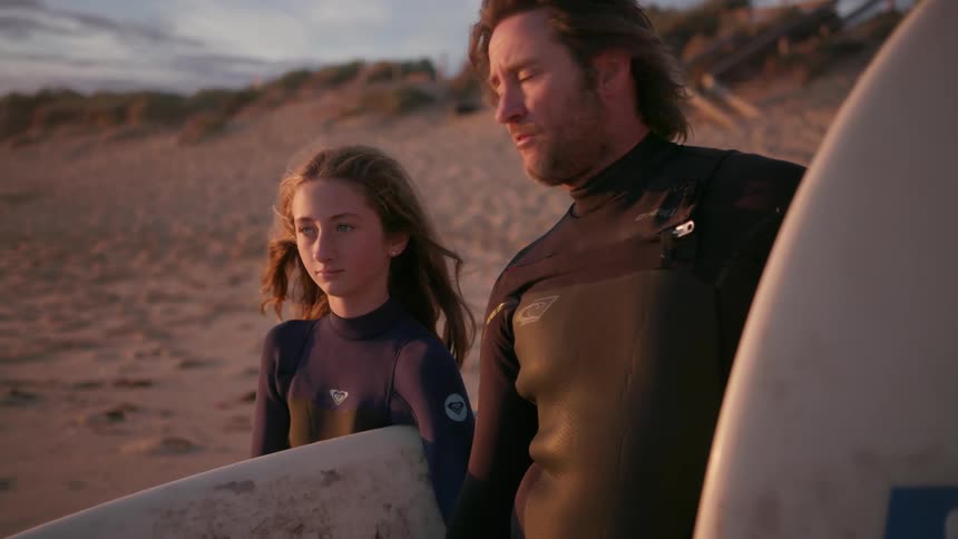 A man and daughter talking on the beach