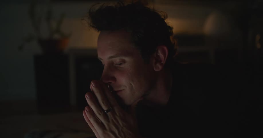 A man stops to think while working on his laptop at home
