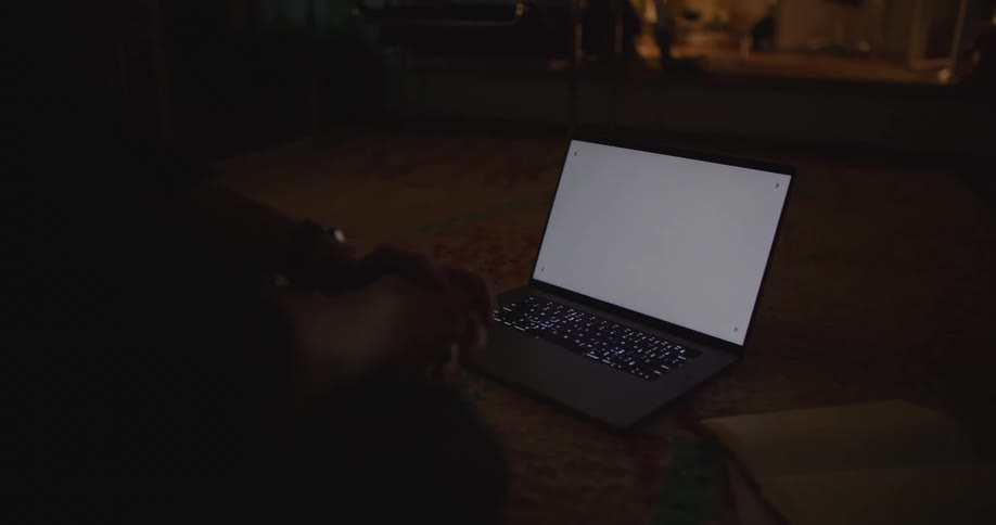 A man sits in front of his laptop at home