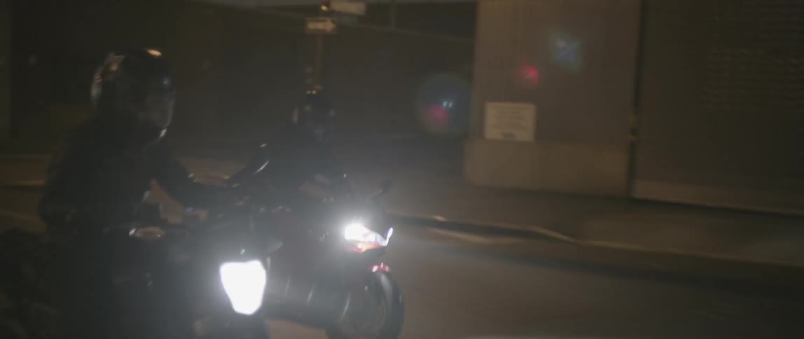Motorcycles race down the street at night