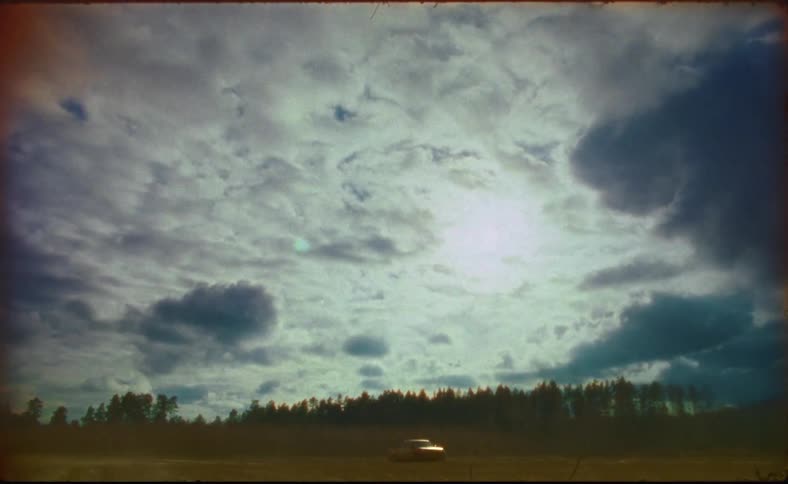 A car is driving over the field