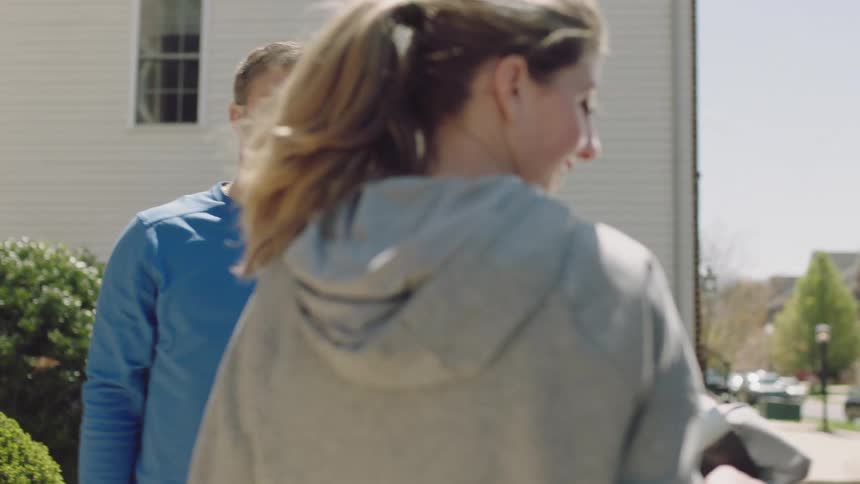 A woman and man are packing items into their car
