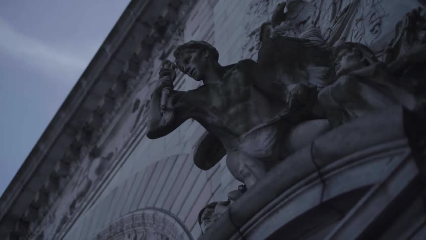 A statue of people is on the wall
