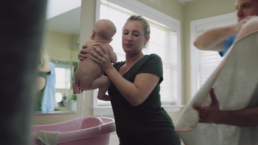 Mom and dad are taking care of there baby indoors
