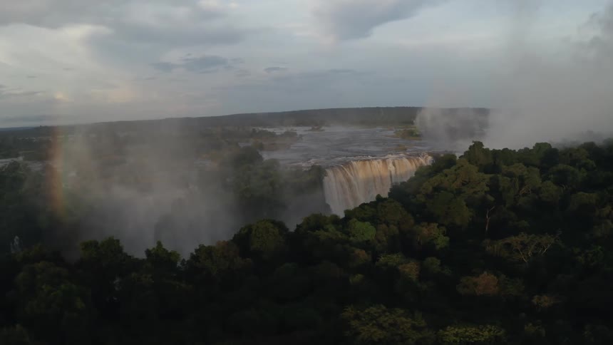 Aerial of rainbow over jungle waterfalls