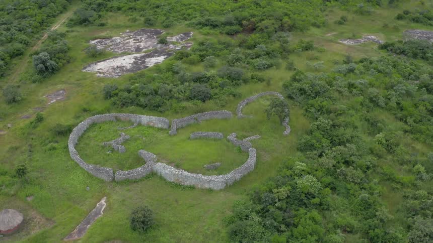 Stone wall ruins in the middle of a green field