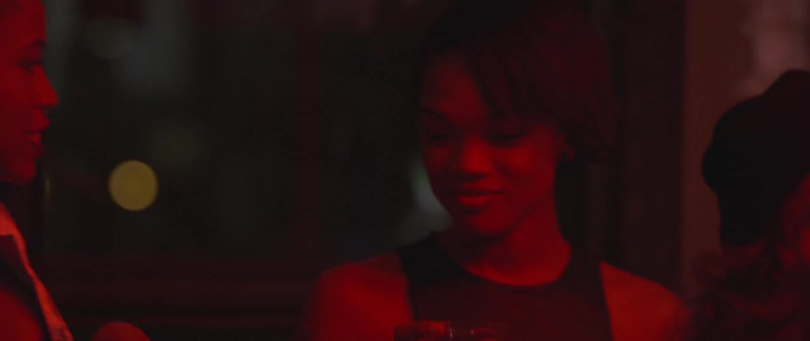 A group of people talk in a red lit room