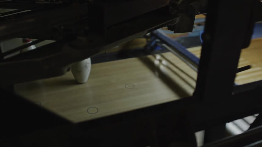 The bowling ball hits the pins
