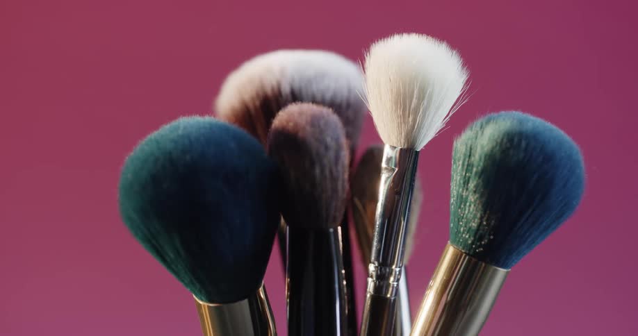 Makeup brushes spin in a cup in a studio