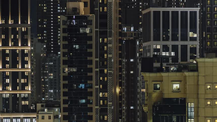Lights turn on and off in tall skyscrapers and buildings downtown at night