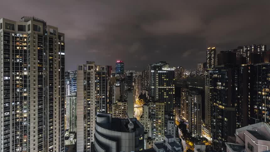 Dense traffic passes through a dense city at night