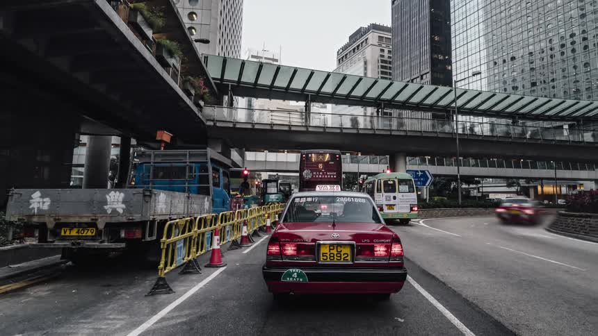 Traffic moves on busy streets around a metropolitan city with skyscrapers and towers all around