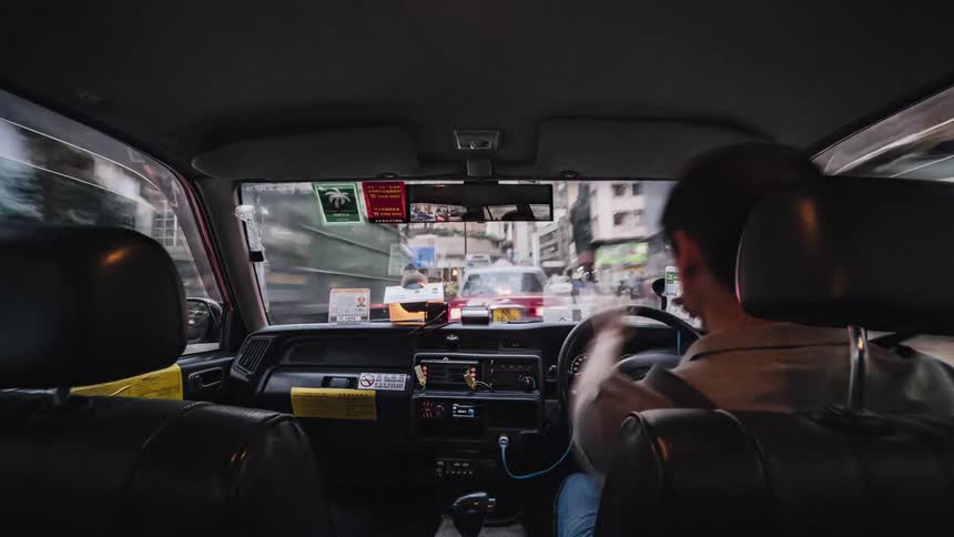 A taxi cab drives through downtown