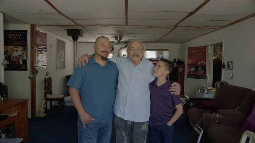 A family stands together at home