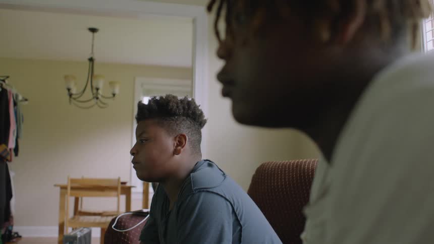 Two youths sit on couch gaming