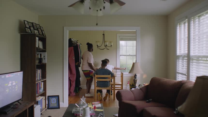 A man brings plates of food to his sons at their dining room table