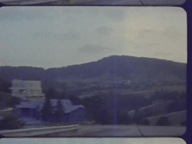 A car travels on the road by the town