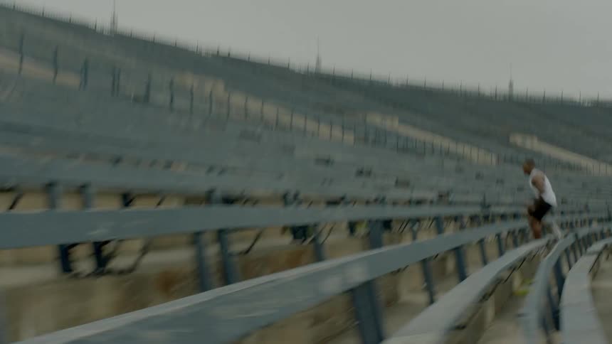 A man running up the stairs in a football stadium