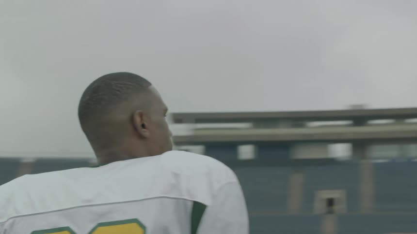 Man in a football uniform walking into a stadium