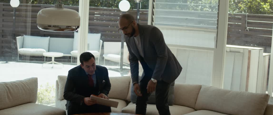 Two men sit down with a folder to talk
