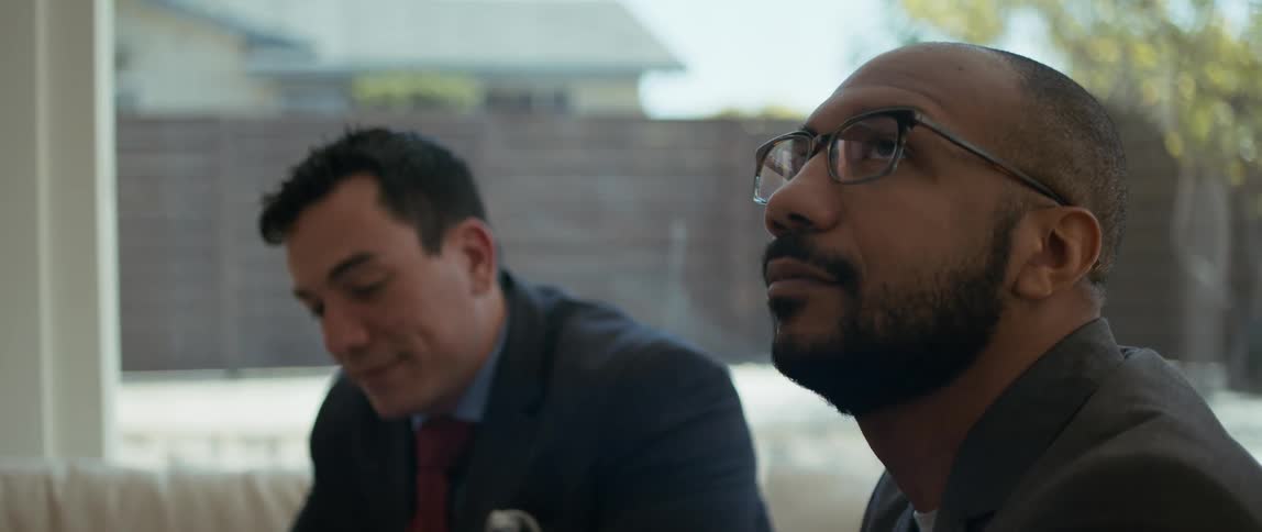 Two men chat while sitting in a backyard