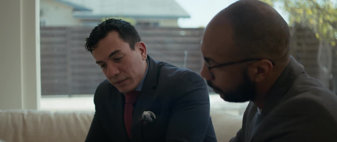 Two men are in the backyard of a home talking