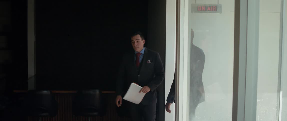 A man leads another man in to a studio